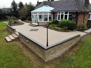 Stunning resin patio installed in Solihull. Featuring block paving diamond feature, finished in gold resin
